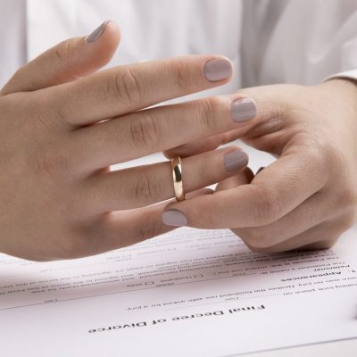 Marriage dissolution concept, close up view of hand taking off engagement ring, panorama